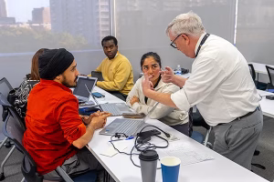 Westcliff University - Dallas campus - Professor working with students at table